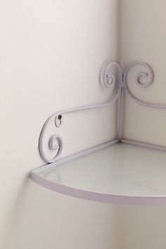 a corner shelf with an iron design on it