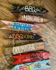 wooden signs are hanging on the wall in different colors and sizes, including one with an arrow