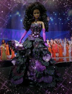 a barbie doll wearing a purple and black dress on display in front of a crowd