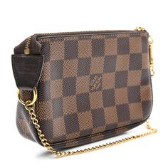 This is an authentic LOUIS VUITTON Damier Ebene Mini Pochette Accessories. This small pochette is crafted of classic brown Louis Vuitton signature Damier canvas. The pochette features a polished gold chain that can form a wristlet and a top zipper that opens to a red fabric interior. Mini Pochette Accessories, Pochette Accessories, Classic Brown, Louis Vuitton Damier Ebene, Damier Ebene, Red Fabric, Authentic Louis Vuitton, Louis Vuitton Damier, Gold Chain