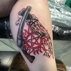 a tattoo on the leg of a person with a knife and pentagramil in it