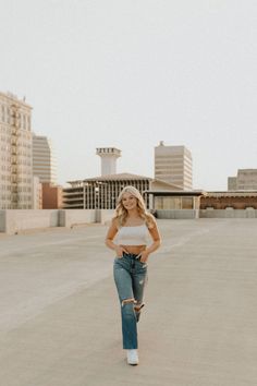 a woman standing in an empty parking lot