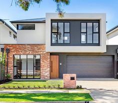 a modern house with two garages in the front yard