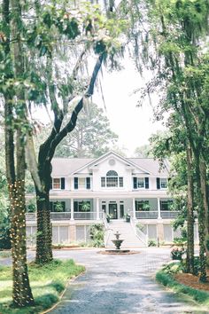 a large white house surrounded by trees and bushes