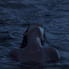 a woman floating in the water with her eyes closed and head tilted to the side