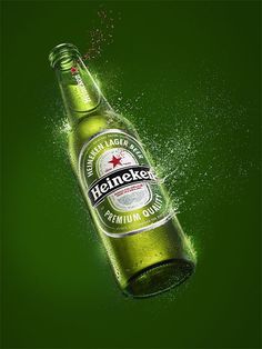 an advertisement for heineken beer with water splashing on the bottle and green background