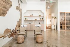 two chairs in the middle of a room with exposed brickwork on the walls and floor