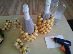 two bottles filled with gold foil and some chocolates on a table next to a pair of scissors