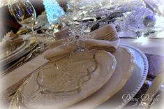 the table is set with white dishes and silverware