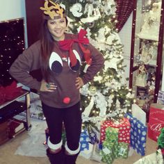 a woman standing in front of a christmas tree