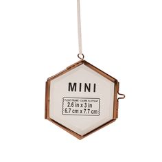 an ornament hanging from a string with the word mini printed on it