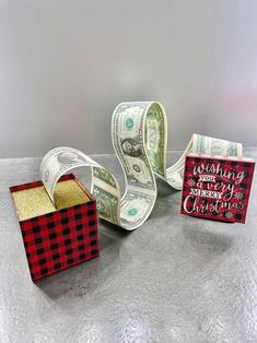 dollar bills are wrapped in red and black paper to look like gift boxes for christmas