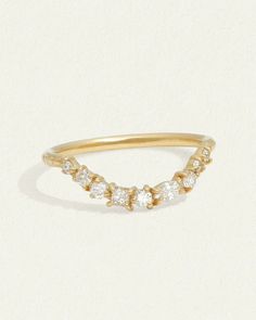 a yellow gold ring with three small white stones on the side and a diamond set in the middle