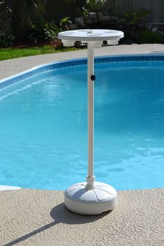 an inflatable pool heater sitting next to a swimming pool with a table on it