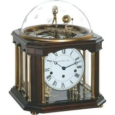 an antique clock with a glass dome on top