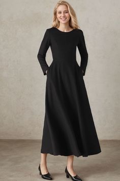 a woman wearing a black dress with long sleeves