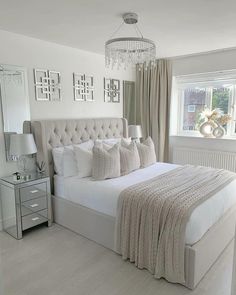 a bedroom with a large bed and chandelier