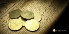 some coins sitting on top of a newspaper