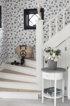 the stairs are decorated with black and white wallpaper, along with a potted plant