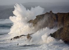 large waves crashing against the rocks in the ocean