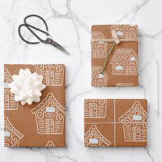 the wrapping paper is decorated with gingerbread houses and white icing, along with a pair of scissors