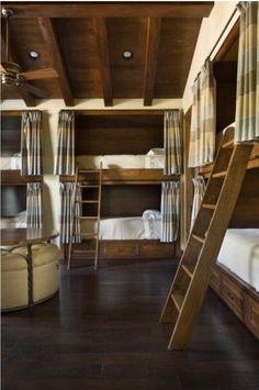 a room with bunk beds and ladders on the ceiling, along with other furniture