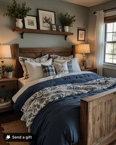 a bed with blue comforter and pillows in a bedroom next to a window,