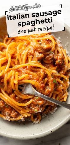 a white bowl filled with pasta and sauce on top of a table next to a fork