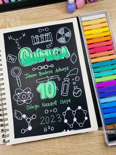 a notebook with the words quimica written on it next to colored crayons