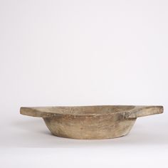 a wooden bowl sitting on top of a white table