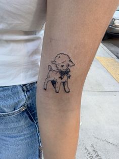 a woman's arm with a small tattoo of a poodle on the side