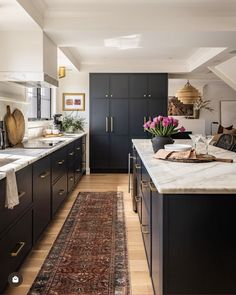 a kitchen with black cabinets and an area rug on the floor that matches the ceiling