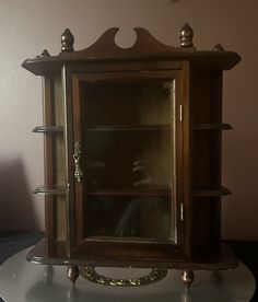 an old wooden cabinet with glass doors and shelves