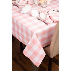 a pink and white checkered table cloth on a dining room table with utensils