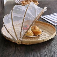 a basket with some food on it and an umbrella over the tray that is holding muffins