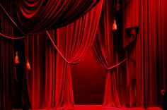 a stage with red curtains and drapes