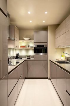 a modern kitchen with stainless steel appliances and white counter tops, along with beige cabinets