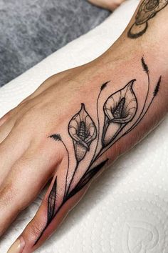 a woman's hand with a flower tattoo on it