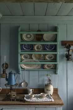 an old fashioned kitchen with plates and tea kettles