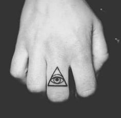 a person's hand with a small tattoo on the middle finger and an all seeing eye