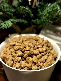 a white bowl filled with cereal next to a christmas tree