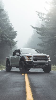 a truck is driving down the road in the fog