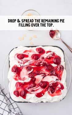 a cake with white frosting and cherries on top, sitting in a glass dish