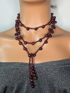 Discover the beauty of our Long Crochet Blood Sandalwood Beaded Necklace, meticulously handcrafted for the bohemian soul. This stunning piece features a harmonious blend of blood sandalwood beads and intricate crochet work, creating a unique and timeless accessory. Perfect for layering or wearing solo, this necklace adds a touch of elegance and earthy charm to any outfit. Ideal as a thoughtful gift for her, this artisanal necklace will surely become a cherished favorite. Embrace the allure of handmade jewelry and elevate your style with this exquisite piece. This beautiful handmade crochet beaded Necklace is made using aromatic sandalwood beads, waxed cord and Measures 60 inches and is a tie-on necklace no clasp and could be wrapped several ways for a different look every time, Simple yet Bohemian Hand Wrapped Beaded Necklaces For Festivals, Bohemian Beaded Necklaces For Festival, Bohemian Fair Trade Adjustable Beads, Natural Wooden Bohemian Jewelry, Natural Wood Bohemian Jewelry, Bohemian Jewelry With Wooden Beads In Natural Color, Natural Bohemian Jewelry With Wooden Beads, Bohemian Brown Lariat Beaded Necklaces, Handmade Adjustable Wood Jewelry