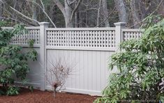 a white fence in front of some trees