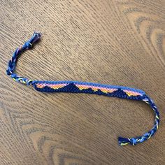 a blue braided lanyard sitting on top of a wooden table