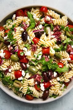 a white bowl filled with pasta salad on top of a table