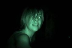 a woman in the dark with green light on her face