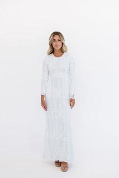 The Danni Dress features an elegant white maxi silhouette with pompom neckline and hip pockets for a touch of whimsy. Fully lined and detailed with lace, this dress is the perfect for your temple attendance and an elegant option for your wedding day. 1st Model Measurements: Hips 34” Waist 25” Bust 32” Height 5’6.5, wearing a size small 2nd Model Measurements: Hips 40.5” Waist 27.5” Bust: 34”, Height 5’7.5, wearing a size small 100% polyester Measurements XS: Bust: 34" | Waist: 27" | Hips 42" | L White Elegant Dress, Lds Temple Dress, Temple Dresses, Temple Dress, Lds Temple, Nursing Friendly, White Maxi, Plus Size Shopping, Gown Wedding