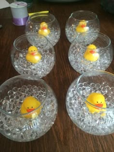 four clear glass bowls with rubber ducks in them